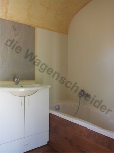 Waschbecken mit Unterschrank, Badewanne mit HPL Wandverkleidung.