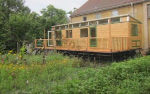 Der Zirkuswagen mit der großen Terrasse steht im Schulgarten.